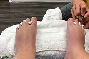 A woman sits, getting her feet done, and then gives a footjob