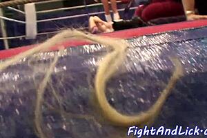 Some muscular women wrestle in boxing cages 