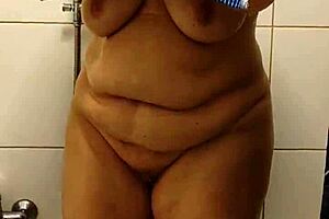A redhead housewife strips off and takes a bath