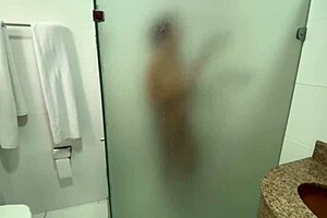 In the shared hostel bathroom, redhead gives handjob during shower