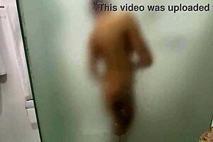 In the shared hostel bathroom, redhead gives handjob during shower
