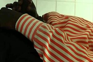 Black gay guy at public urinal stroking cock while spying.