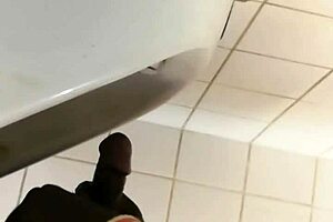 Black gay guy at public urinal stroking cock while spying.