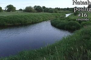 Natasha intriguingly poses in a bikini near the river, undressing privately in nature