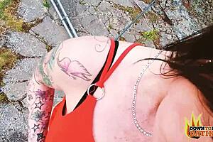 A tattooed, dark-haired mature woman with no pubic hair has sex in a doggy style position outside, camera in point of view