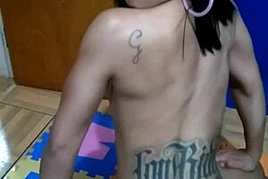 brunette tattooed girl sits on the console topless for the first time in a sensual way