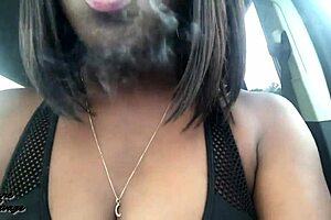 ebony beauty enjoys a cigarette in the car