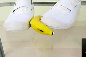 The girl says, 'watch me crush this banana with my feet.'