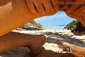 My sandy ass shows red butt plug at beach.