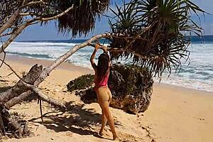 My sandy ass shows red butt plug at beach.