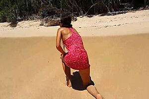 My sandy ass shows red butt plug at beach.