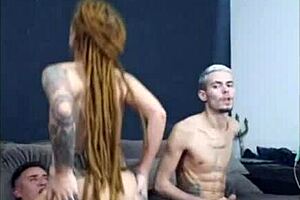 Redhead with dreads sitting with friend while his wife chats nicely in group