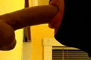 Hooded gay guy deepthroats dildo intensely.