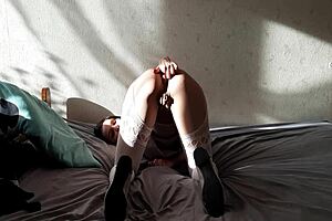 A submissive wife, who is kneeling for her dominant partner, undresses