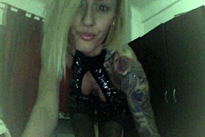 blonde cam girl performs striptease at home in black stockings.