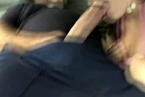 a couple enjoys a blowjob in their car outdoors.