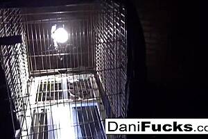 Dani Daniels teases with her big tits while masturbating in a cage.