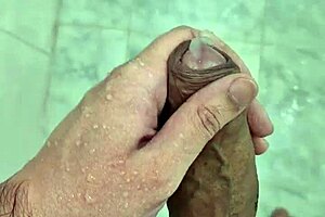 A big guy gives a solo handjob in the bathroom and ends up cumming