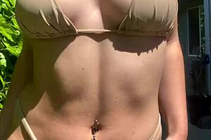 Brunette beauty in bikini, trying out summer clothes