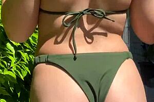 Brunette beauty in bikini, trying out summer clothes
