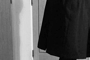 A crossdresser in self-bondage in a uniform