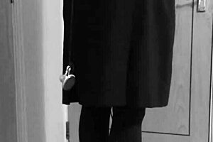 A crossdresser in self-bondage in a uniform