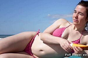 A young man relaxes on the beach and a woman gives him a sensual massage