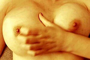 Cutie massages her slippery tits while jerking off in a casual scene.