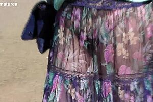 Matură păroasă etalează corpul dolofan în rochie transparentă pe stradă