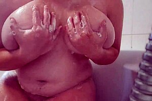 I watch this busty teen massage her soapy breasts at home.