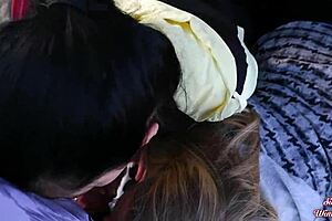 A couple of girls are giving a blowjob to the guy in the car trunk