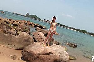 skinny japanese chick enjoys having a photoshoot on the beach