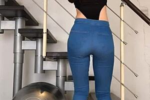 Chinese woman dancing in tight jeans, her tight clothing hugging her body to the music.